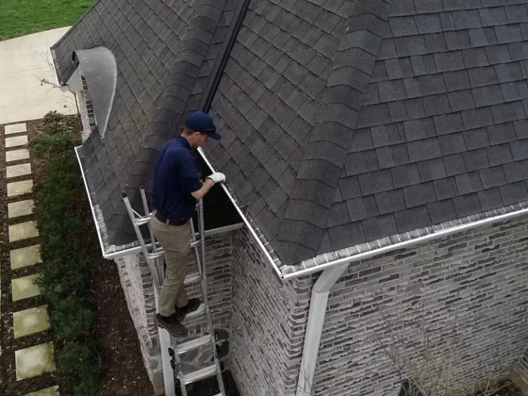 Demarks professional with white gloves cleaning gutter