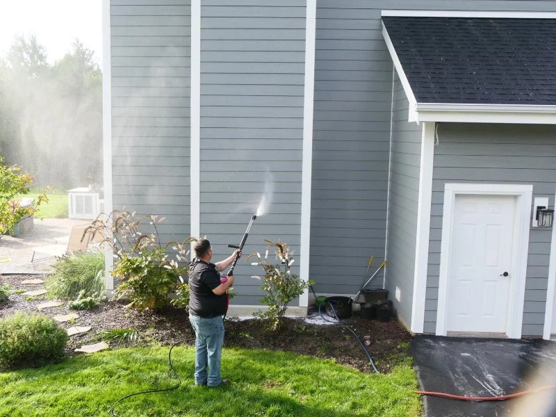 Demarks cleaning professional cleaning siding on gray home
