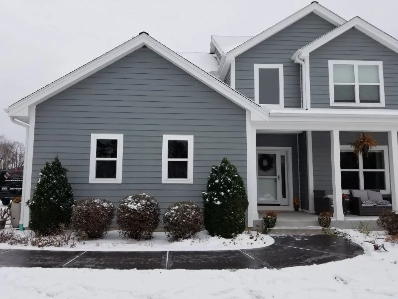 gray house with clean walkway after snow removal