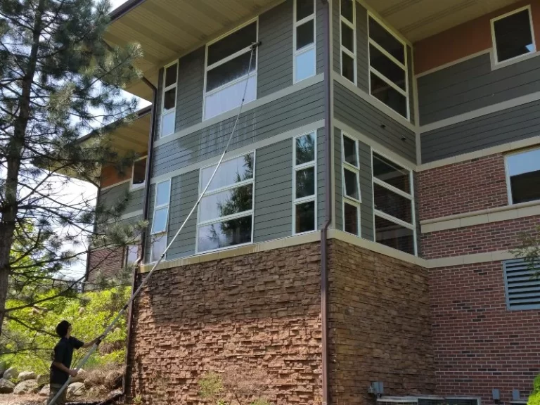 brick house with gray siding and Demarks professional cleaning windows